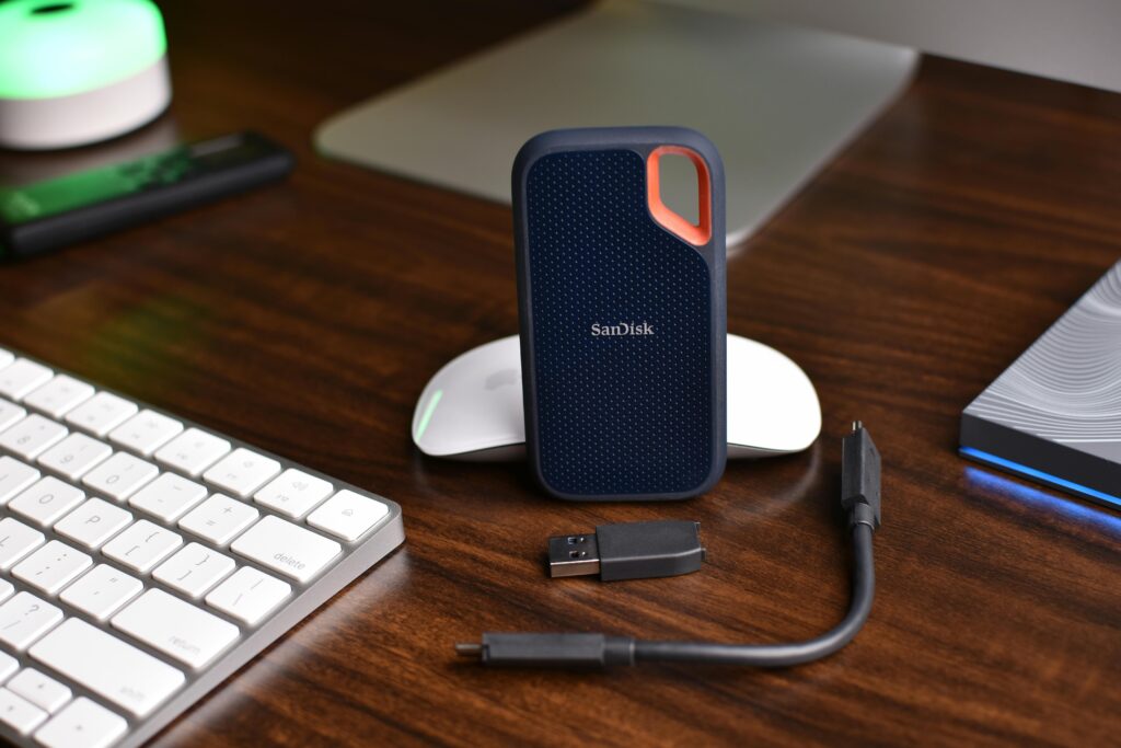 A SanDisk Extreme Portable SSD Beside a Usb Drive and Cable